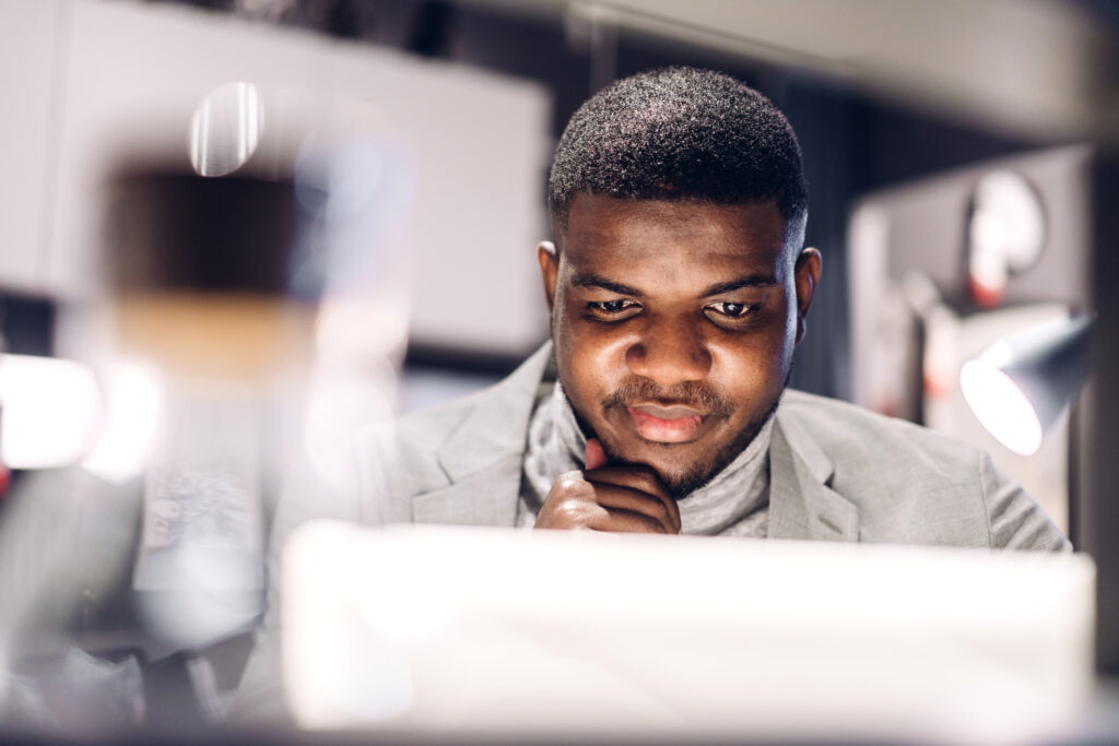 Young black african man relaxing using laptop computer working and video conference meeting at home.Young creative african man talk with headset.work from home concept